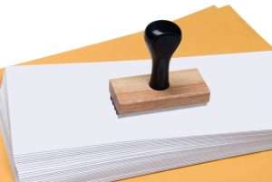 Envelopes and rubber stamp representing denials management